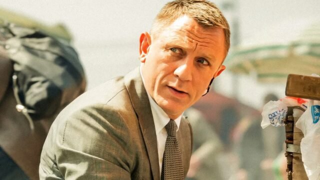 daniel-craig-s-james-bond-looking-to-the-side-while-people-cower-behind-him-in-the-skyfall-movie.jpg
